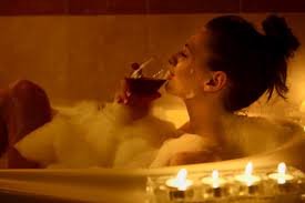woman drinking wine in bubble bath