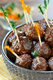 Bowl ofsauce covered meatballs with tooth picks poked in them